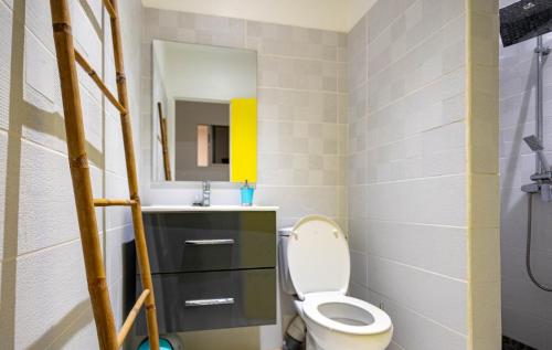 a bathroom with a toilet and a sink and a mirror at Kanelle in Baie-Mahault