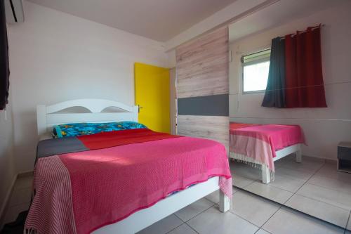 a bedroom with two beds and a window at Kanelle in Baie-Mahault