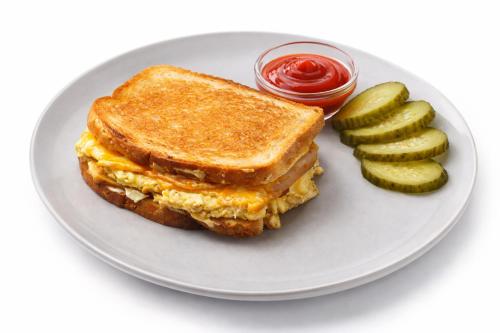 Een eiersandwich en augurken op een bord met ketchup. bij Avto Spa in Chmelnytsky