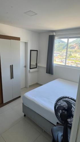 a bedroom with a bed and a large window at Ap Alto São Bento in Itapema