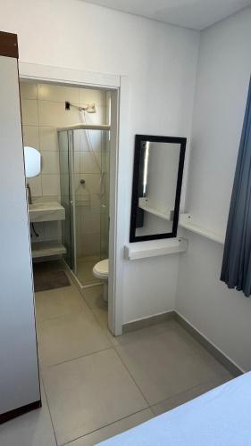 a bathroom with a toilet and a mirror at Ap Alto São Bento in Itapema