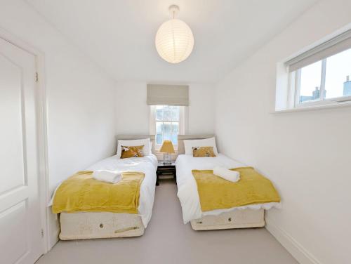 two beds in a room with white walls at 1a Tower Street - Emsworth in Emsworth