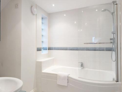a white bathroom with a tub and a sink at 1a Tower Street - Emsworth in Emsworth