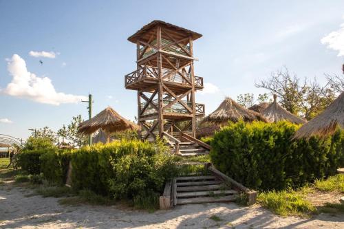 een resort met een toren en wat struiken bij La Colibe, cătun arhaic ecologic in Constanţa