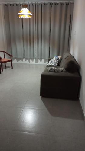 a bed sitting in a room with a window at Apê Ponta da Praia Santos in Santos