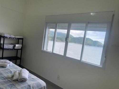 a bedroom with a window with a view of the water at Apê Ponta da Praia Santos in Santos
