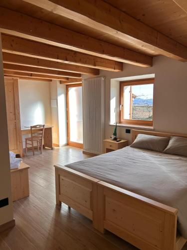 a bedroom with a large bed and a table at Agriturismo El Bocolar in Marano di Valpolicella