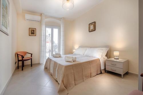 a bedroom with a bed and a chair and a window at Busacca Suite in Scicli