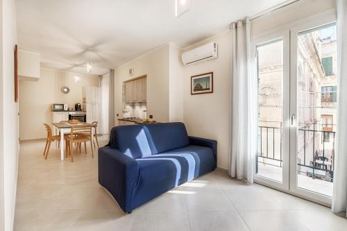 a living room with a blue couch in front of a window at Busacca Suite in Scicli