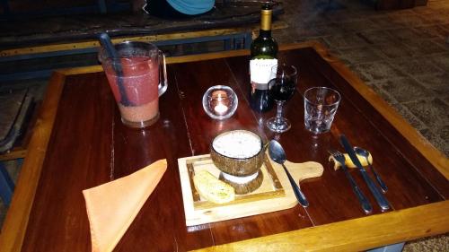 a table with a plate of food and a bottle of wine at Celeste Mountain Lodge in Bijagua