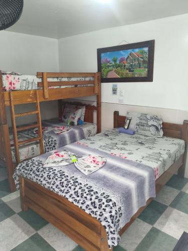 a bedroom with two bunk beds and a painting on the wall at HOTEL NUEVO GALEX in Acacías