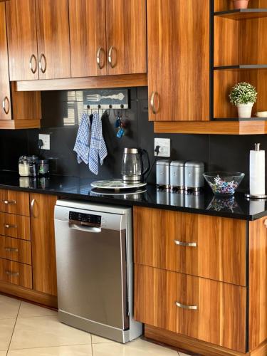 een keuken met houten kasten en een roestvrijstalen vaatwasser bij Casa Mia in Jeffreys Bay