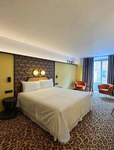 ein Hotelzimmer mit einem großen Bett und einem Stuhl in der Unterkunft Hotel Divino by Fimedhotels in Figueres