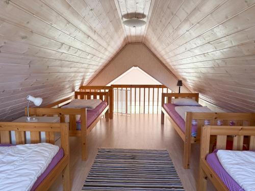 a room with four beds in a room with a roof at Nobel Cabins - Furillen in Lärbro