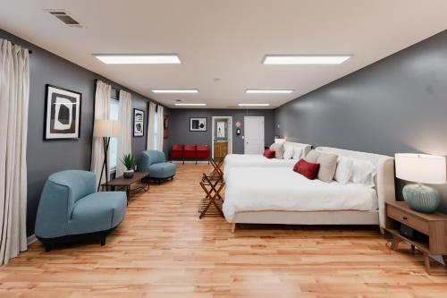 a bedroom with a white bed and blue chairs at The Alabama Guest House in Englewood