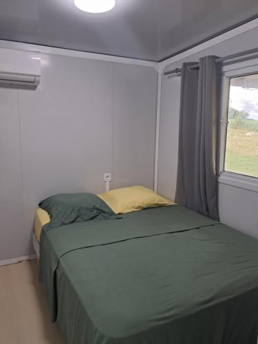a small bedroom with a bed and a window at Villa Océanne in Grand-Bourg