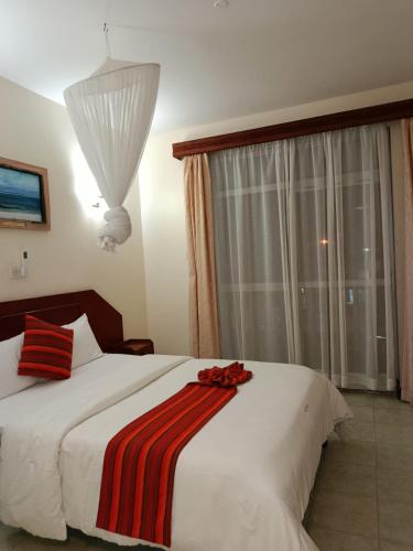 a bedroom with a large bed with red roses on it at Raya hotel Nyali Mombasa in Mombasa
