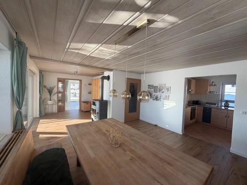 a living room with a table and a kitchen at Ferienhaus am Hang in Bad Wurzach