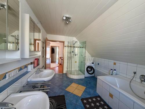a bathroom with two sinks and a tub and a shower at Ferienhaus am Hang in Bad Wurzach