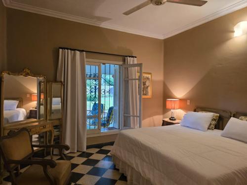 sypialnia z łóżkiem, lustrem i oknem w obiekcie Oasis Colonial w mieście Asunción