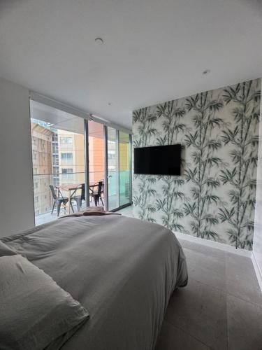 a bedroom with a bed and a flat screen tv at VV - Skyline Studio Pool & Gym in City Centre in Gibraltar