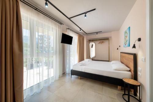 a bedroom with a bed and a large window at The Blue Wave Hotel in Himare