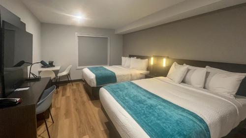 een hotelkamer met twee bedden en een televisie bij Studio 6 Fort Frances ON in Fort Frances