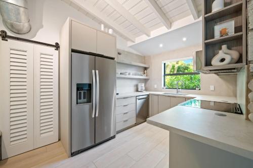 a kitchen with a stainless steel refrigerator at Coconut Grove Mid-Century Jungle Oasis in Miami