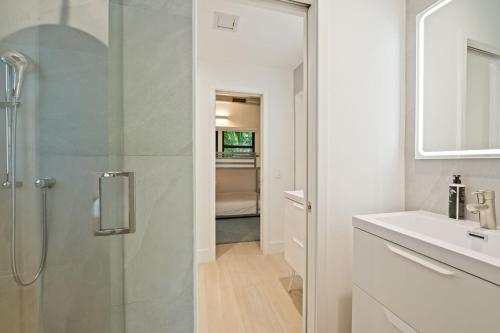 a white bathroom with a shower and a sink at Coconut Grove Mid-Century Jungle Oasis in Miami