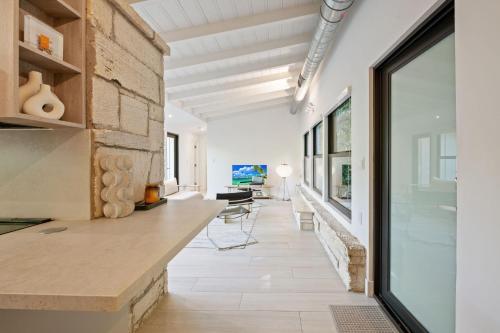 a kitchen with a stone wall and a large window at Coconut Grove Mid-Century Jungle Oasis in Miami