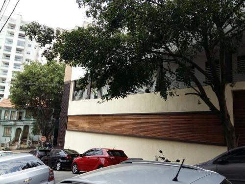 a parking lot with cars parked in front of a building at Suíte casal Bela Vista 207 in São Paulo