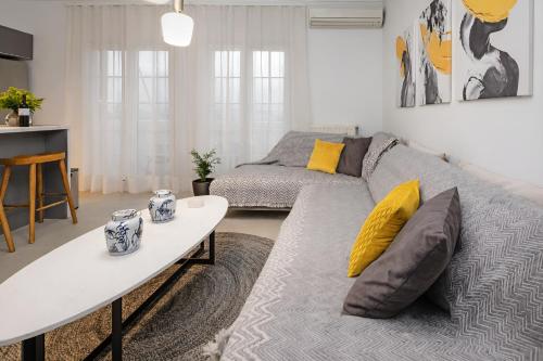 卡拉马塔Singer Suite Kalamata , Close to Center & Easy Street Parking的客厅里有一张沙发和一张桌子。