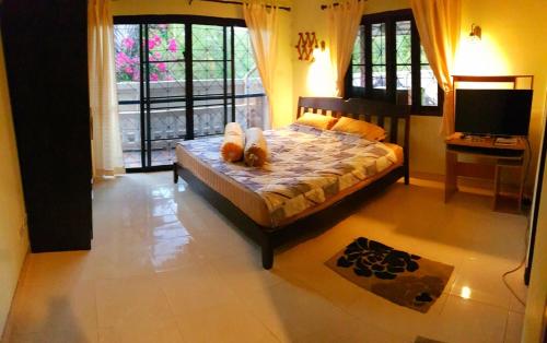 a bedroom with a bed with a teddy bear on it at Jasmine's Bungalow in Ban Saiyuan (1)