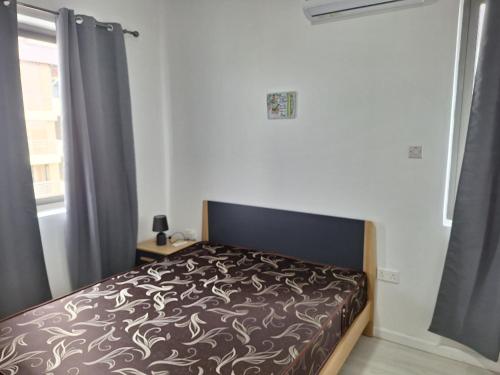 a bedroom with a bed and a window at Lumea Apartment in Flic-en-Flac