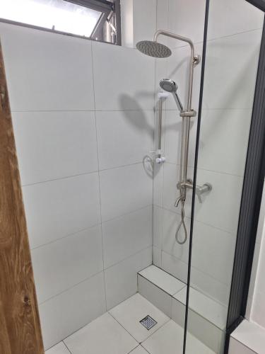 a shower with a glass door in a bathroom at Lumea Apartment in Flic-en-Flac
