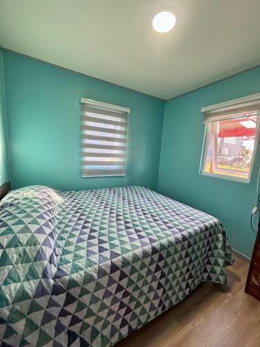 a bedroom with a bed in a room with blue walls at Cabaña Los Lagos 2 in Lenca