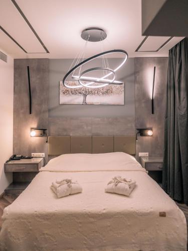 ein Schlafzimmer mit einem großen Bett, auf dem zwei Handtücher liegen in der Unterkunft Pantelidis Hotel & Spa in Ptolemaida