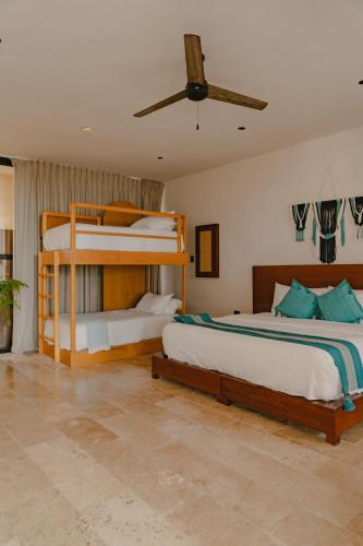 a bedroom with two bunk beds and a fan at Totem Beach Club - Celestun in Celestún