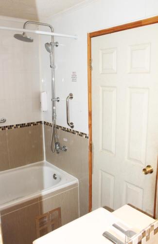 a bathroom with a bath tub and a shower at Residencial Victoria Said in Linares