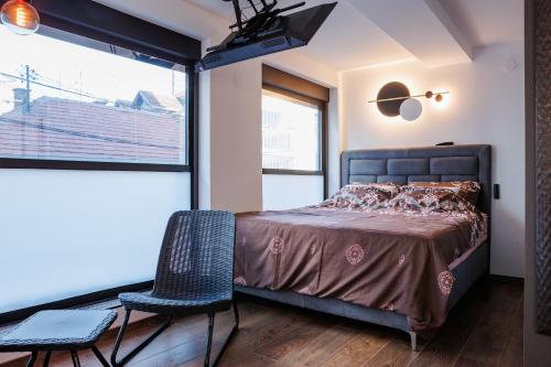 a bedroom with a bed and a chair and a window at Star&spa in Niš