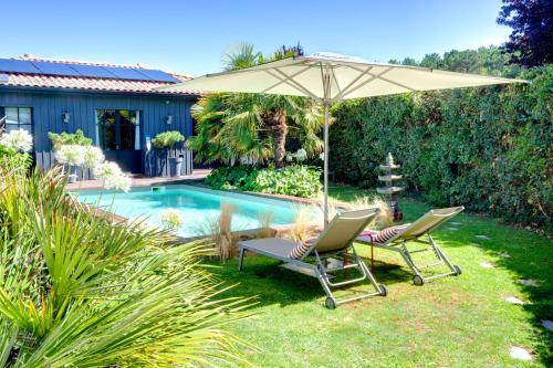 een paar stoelen en een parasol naast een zwembad bij Chambres d'hôte Ô Bois Plage in Gujan-Mestras