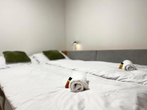 two white beds with towels on top of them at Panorama Tatry Apartment in Jezersko
