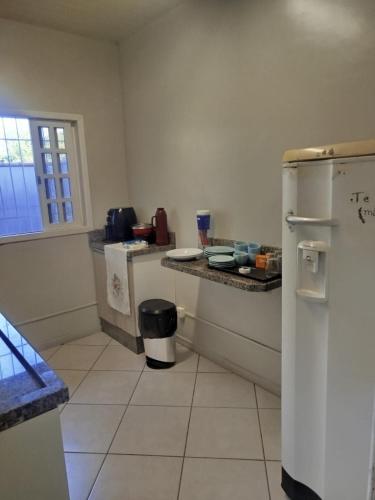 a kitchen with a refrigerator and a counter at Pousada Central Quarto 5 in Joinville