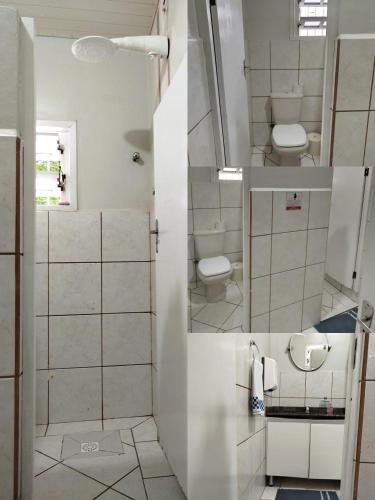 a bathroom with two toilets and a sink and a shower at Pousada Central Quarto 5 in Joinville
