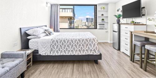 a bedroom with a bed and a kitchen with a window at Hawaiian monarch cozy studio in Honolulu