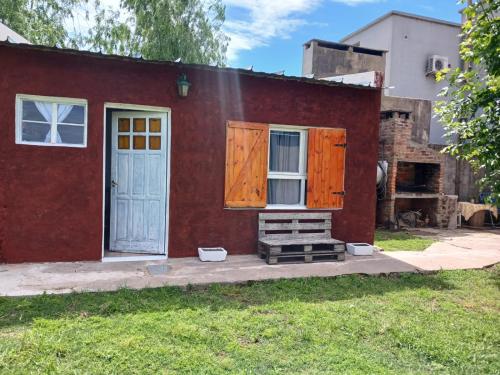 a red house with a white door and windows at Apart Los lirios in La Porteña