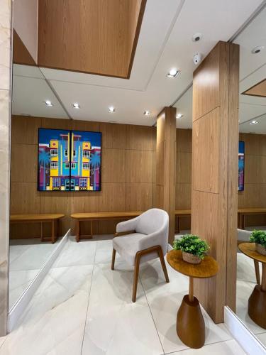a waiting room with a chair and a tv at Apto Home & Club em Capão da Canoa in Capão da Canoa