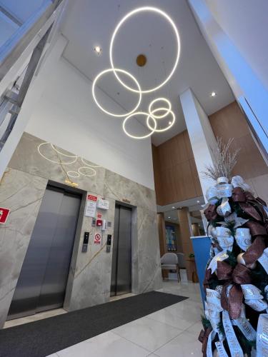 an office lobby with a ceiling with a chandelier at Apto Home & Club em Capão da Canoa in Capão da Canoa