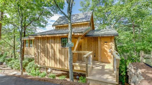 a tree house with a porch and a roof at The Blackjack Oak in Treehouse Grove at Norton Creek in Gatlinburg