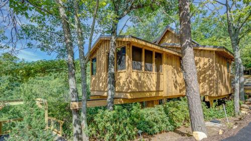 a wooden house in the middle of trees at The Blackjack Oak in Treehouse Grove at Norton Creek in Gatlinburg